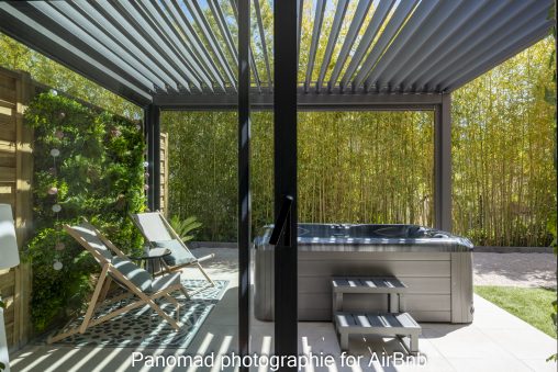 Espace extérieur convivial pour accueillir les invités sur Airbnb : tables, jacuzzi et chaises.